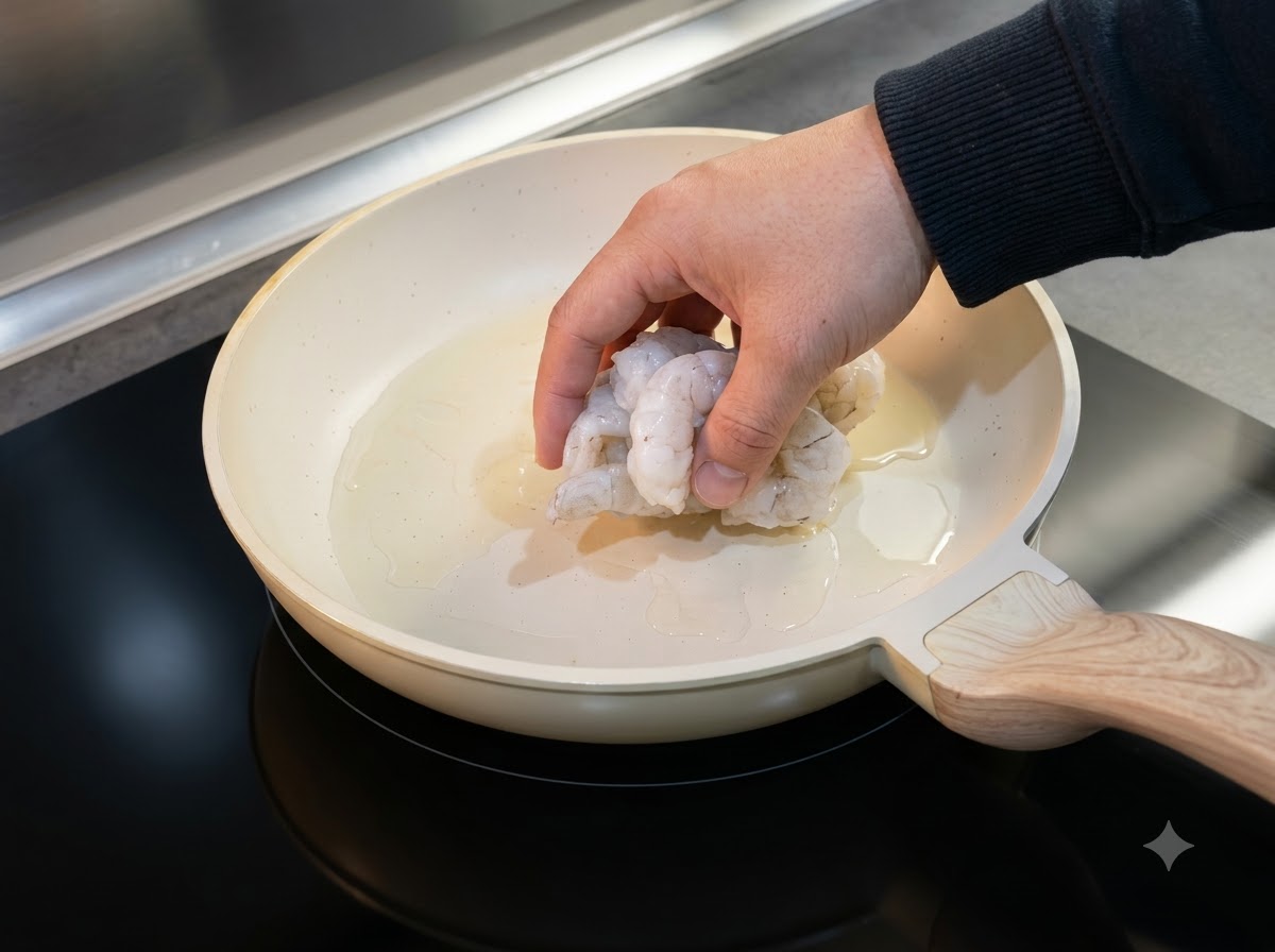Aufgetaute Garnelen werden zum Kochen in eine geölte Pfanne gelegt.