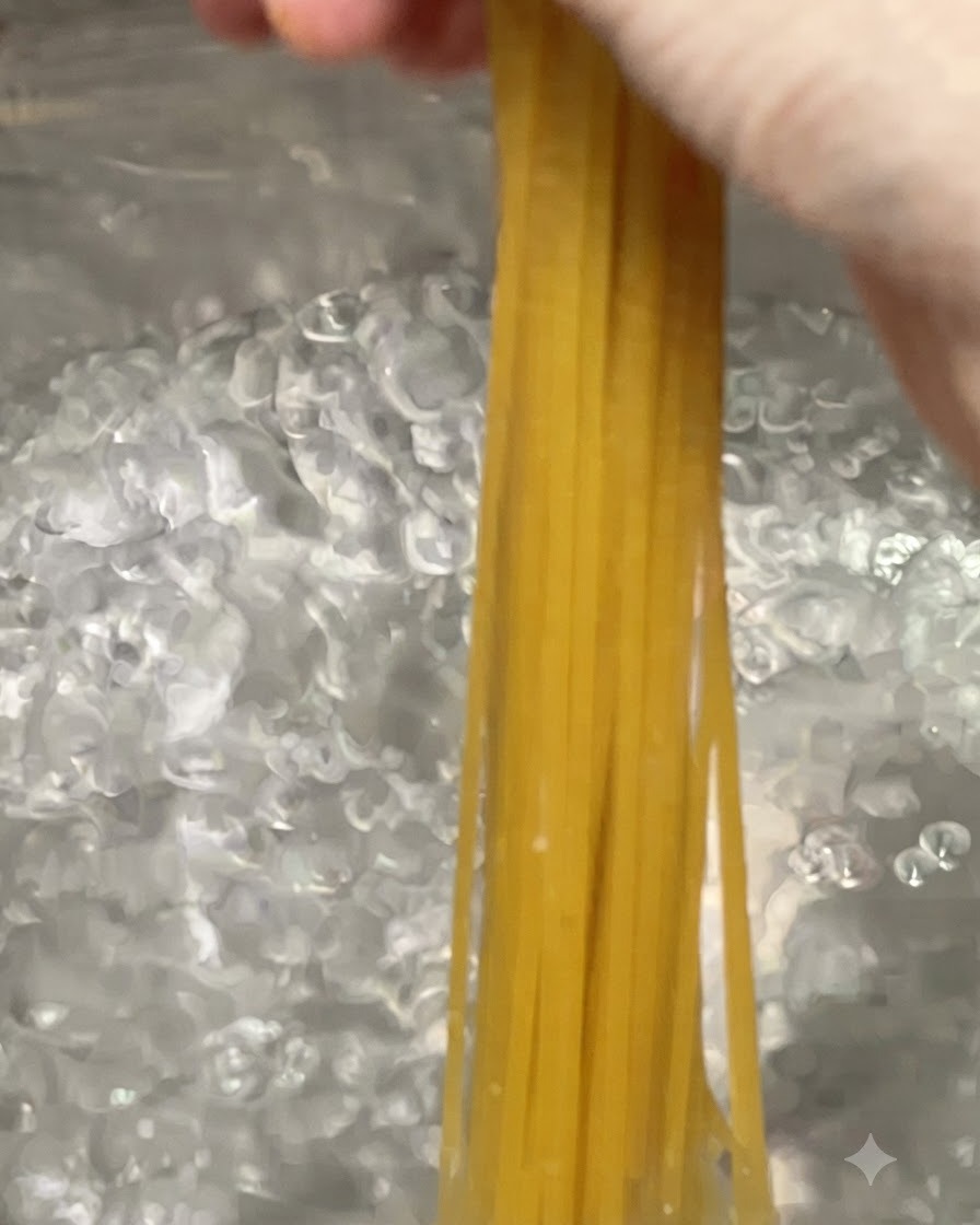 Spaghetti-Nudeln werden in einen großen Topf mit kochendem Wasser gegeben.