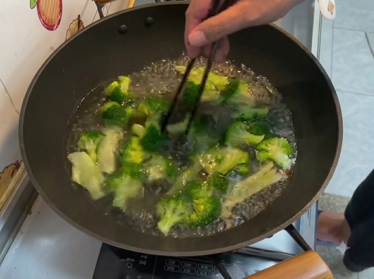 Leuchtend grüne Brokkoliröschen kochen in Wasser in einem Wok und werden mit Stäbchen umgerührt.