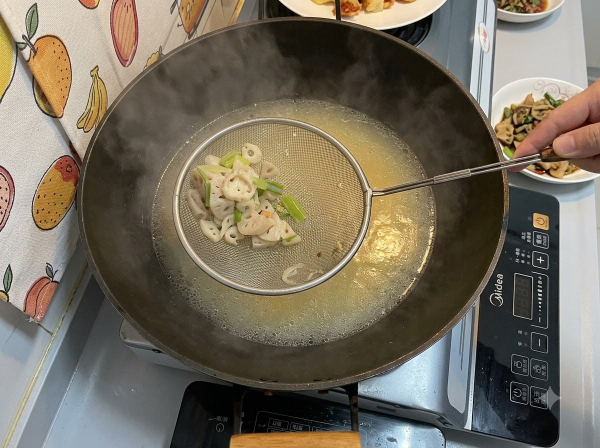 Ein Schaumlöffel aus Metall hält gefilterte feste Stücke über einem Wok, der mit einer köchelnden, gelblichen Brühe gefüllt ist.
