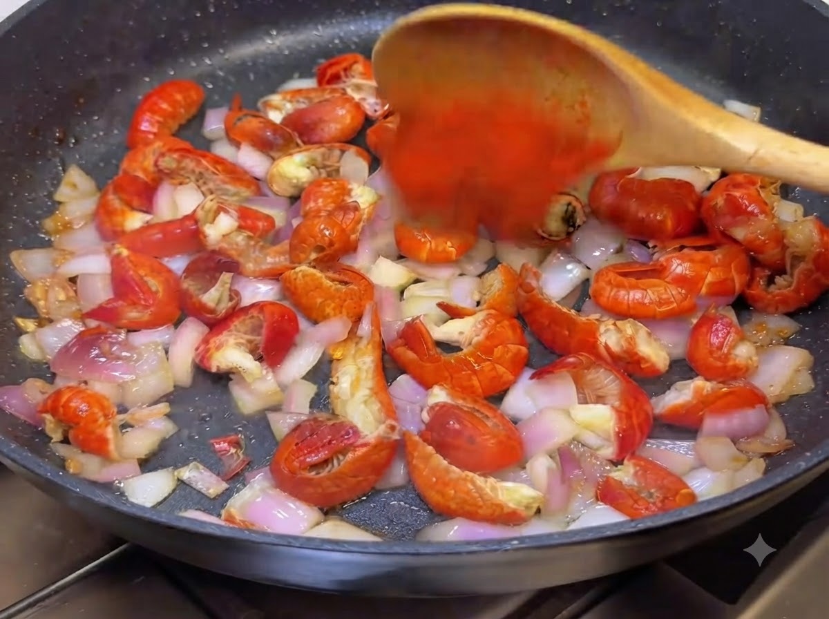 Chilipulver und koreanische scharfe Sauce werden mit einem Holzlöffel in die Pfanne eingerührt.