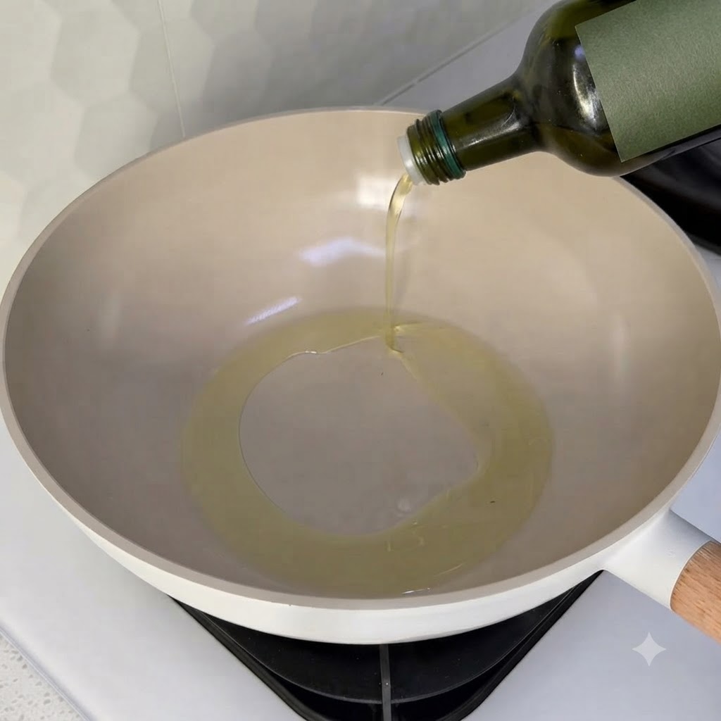 Speiseöl wird in einen sauberen Wok auf einer Herdplatte gegossen.