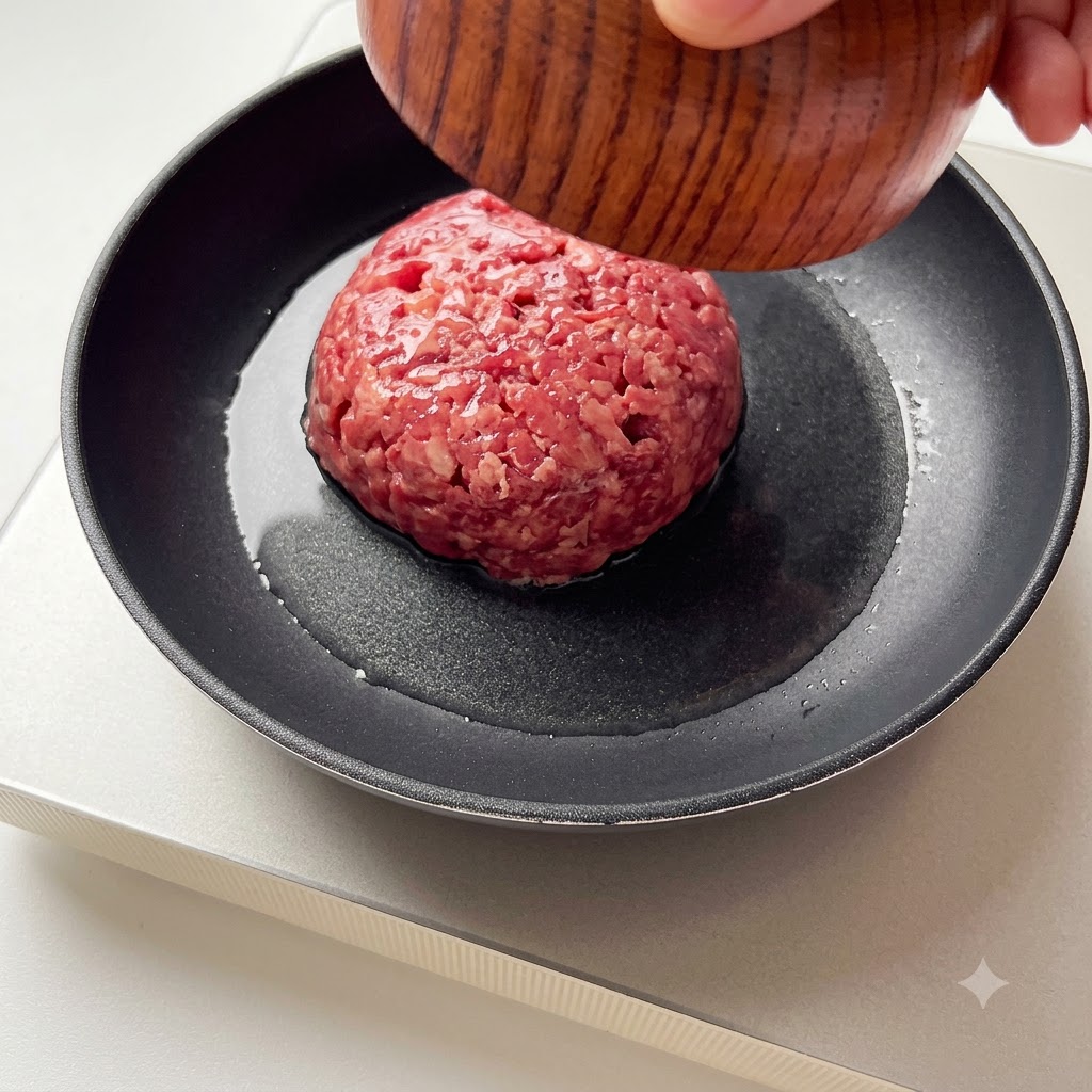Rinderhackfleisch wird in eine heiße Bratpfanne gegeben.