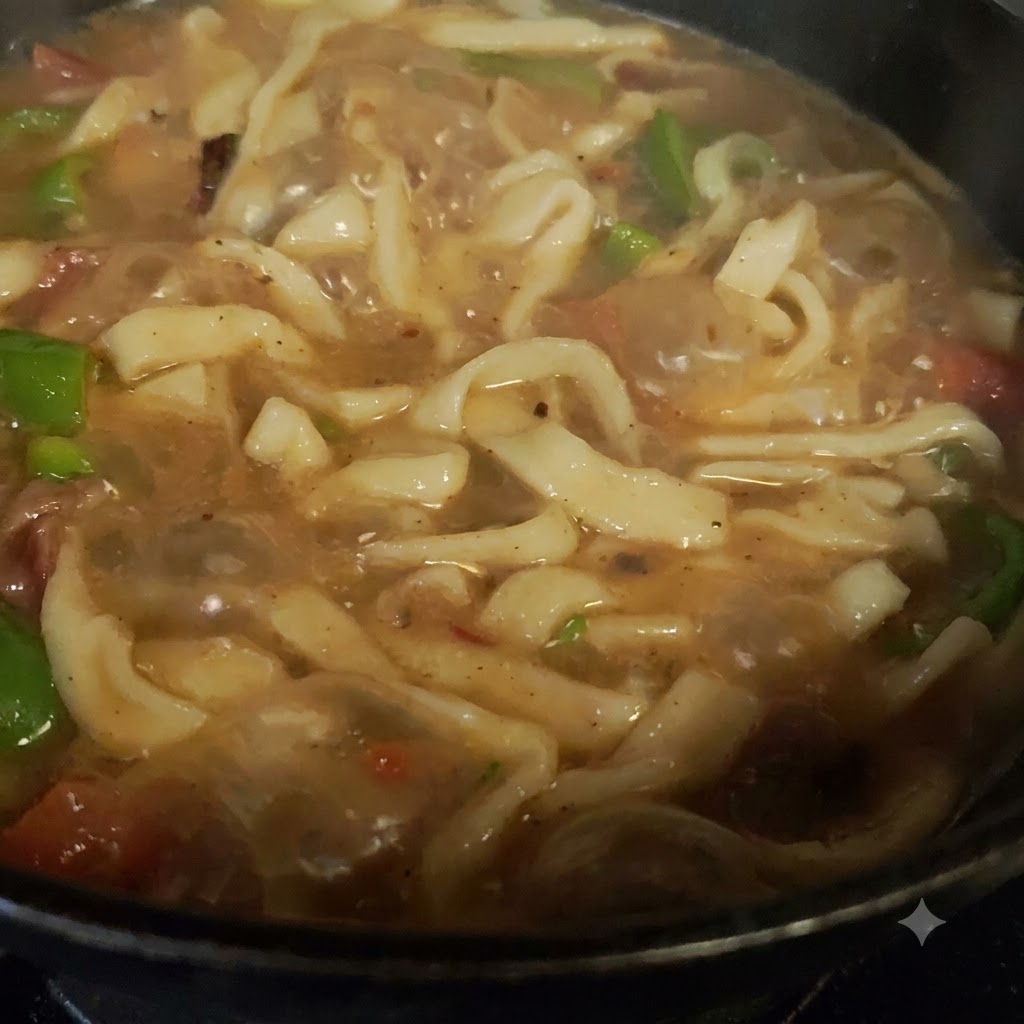 Frische grüne Paprika und Tomaten, die im Kochtopf mit Fleisch vermischt sind.