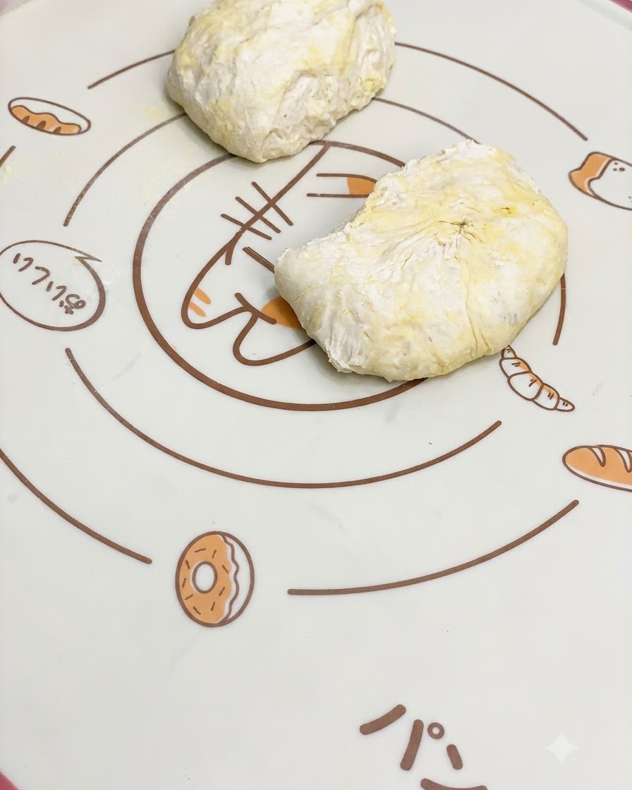 Portionen von fermentiertem Pizzateig ruhen auf einer gemusterten Silikon-Backmatte.