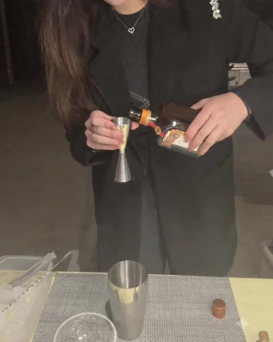 Cointreau, der in einen Jigger mit einem darunterliegenden Shaker-Becher gegossen wird.