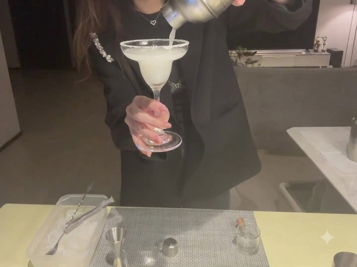 Eine Nahaufnahme einer Zitronenscheibe, die sorgfältig am Rand eines Margaritaglases angebracht wird.
