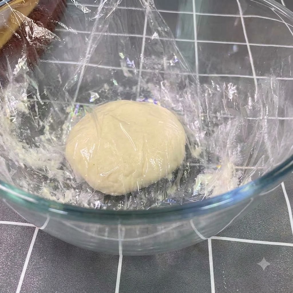 Fermentierter Teig ruht und ist in einer großen Glasschüssel auf das doppelte Volumen aufgegangen.