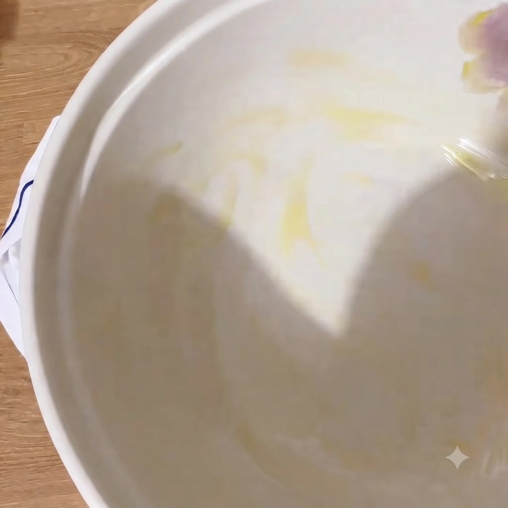 Das Innere einer weißen Schüssel glänzt mit einer Schicht nativem Olivenöl extra.