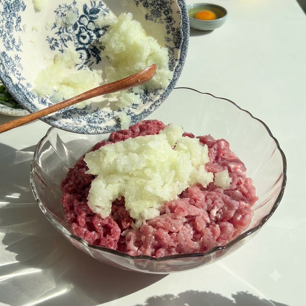 Fein gehackte Zwiebeln und Petersilie werden aus einer dekorativen Schale in eine Glasschale mit rohem Hackfleisch gegeben.