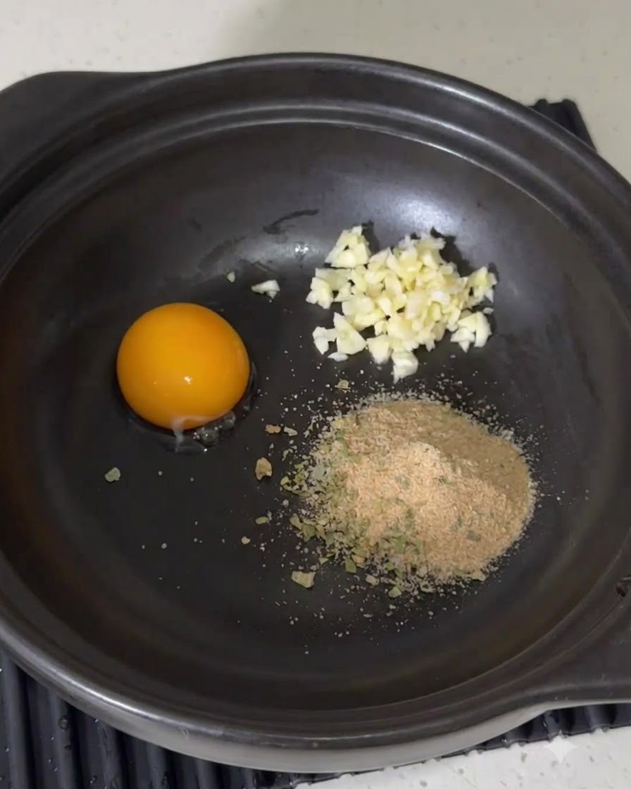 Mayonnaise wird aus einer Flasche in die Würzmischung im Topf gedrückt.