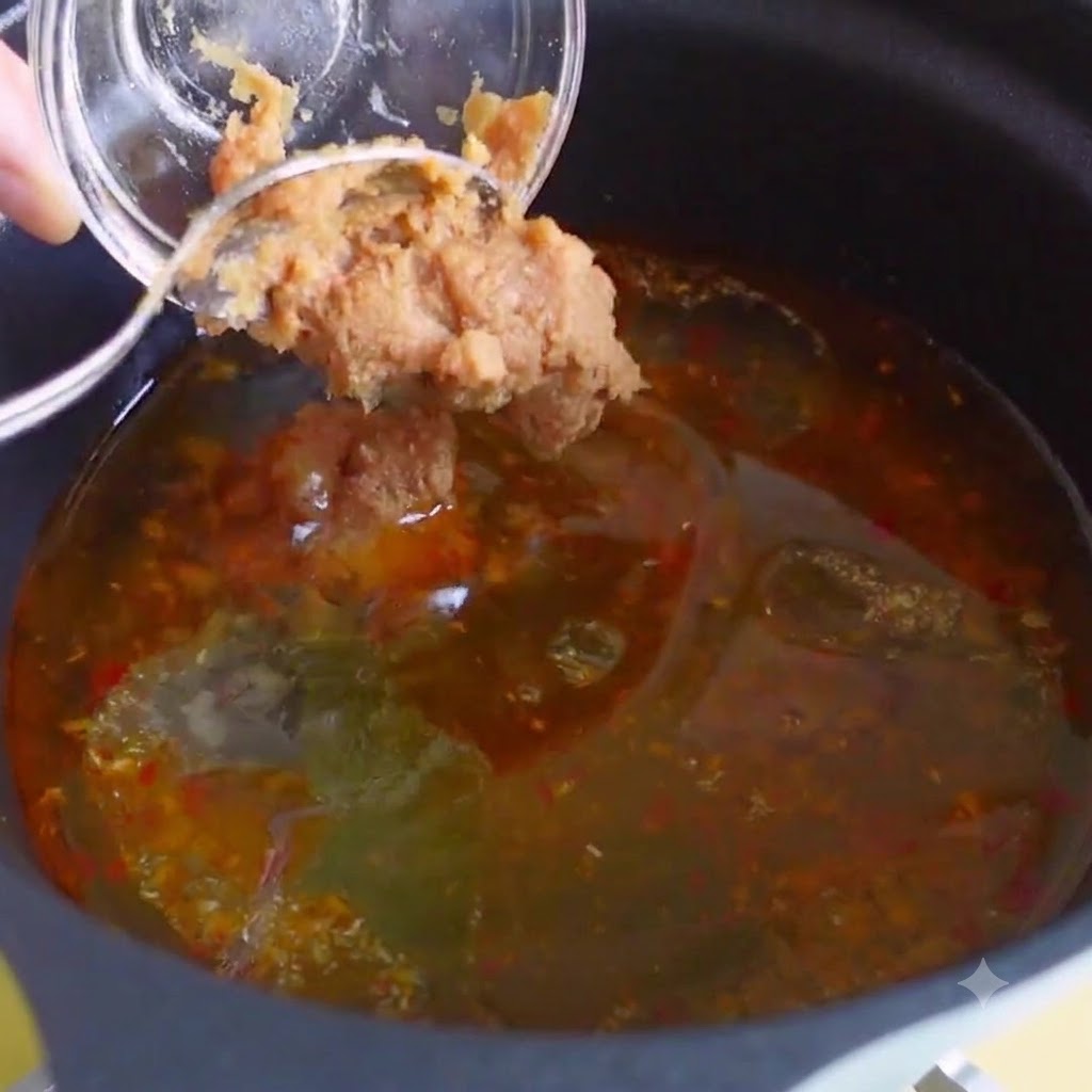 Huehnerbouillon, Bonito-Extrakt und koreanische Chilipaste werden in die Suppenbruehe gemischt.