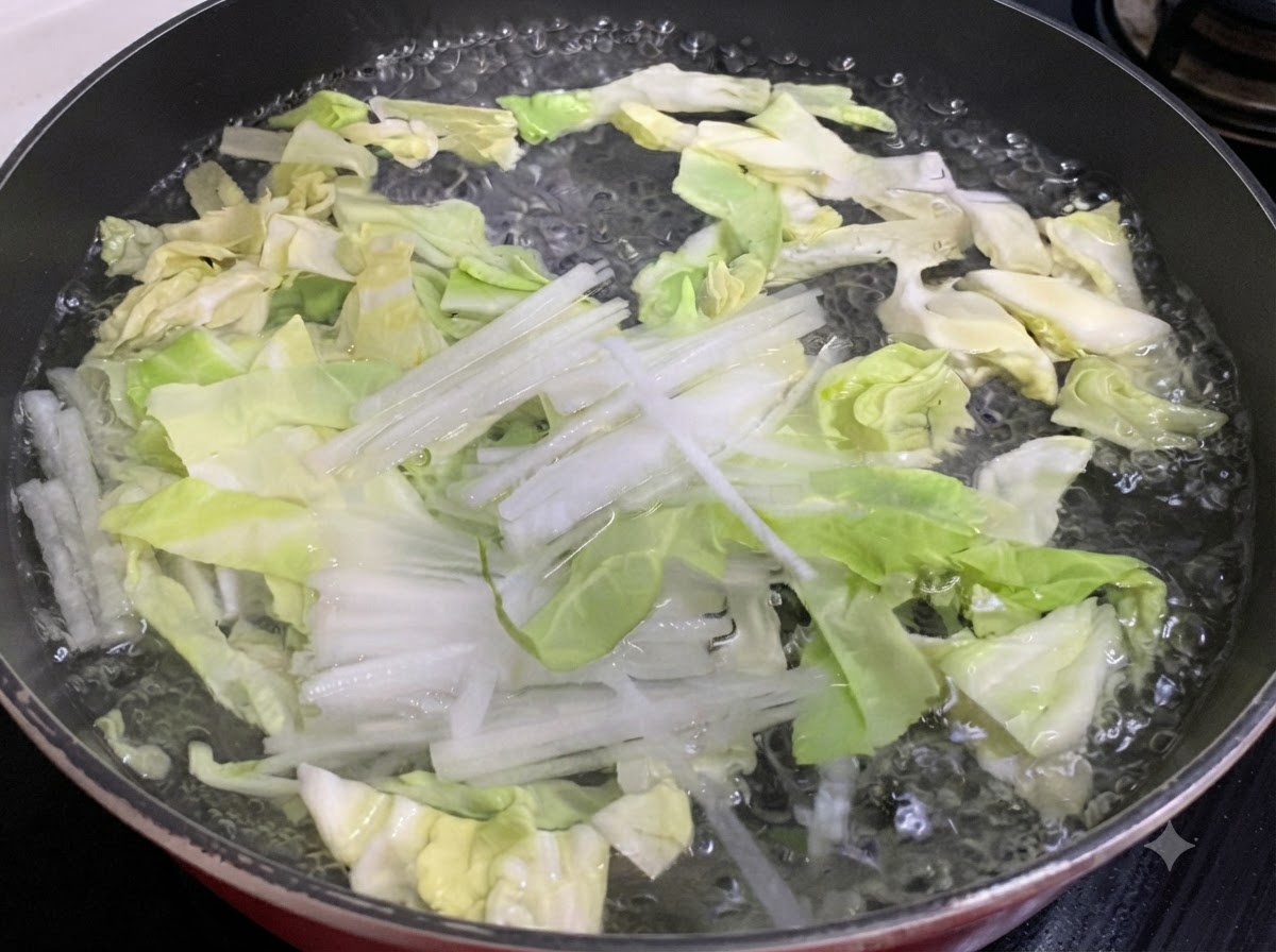 In Streifen geschnittener Kohl und weißer Rettich kochen in einem Topf mit Wasser.