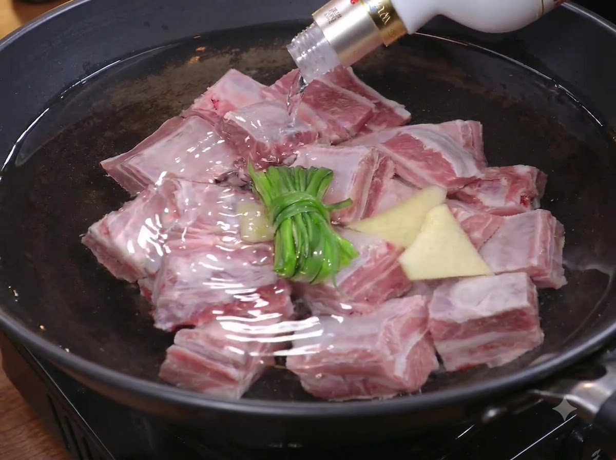 Steakstücke werden zum Blanchieren in einen Topf mit Wasser, grünen Zwiebeln und Ingwer gegeben.