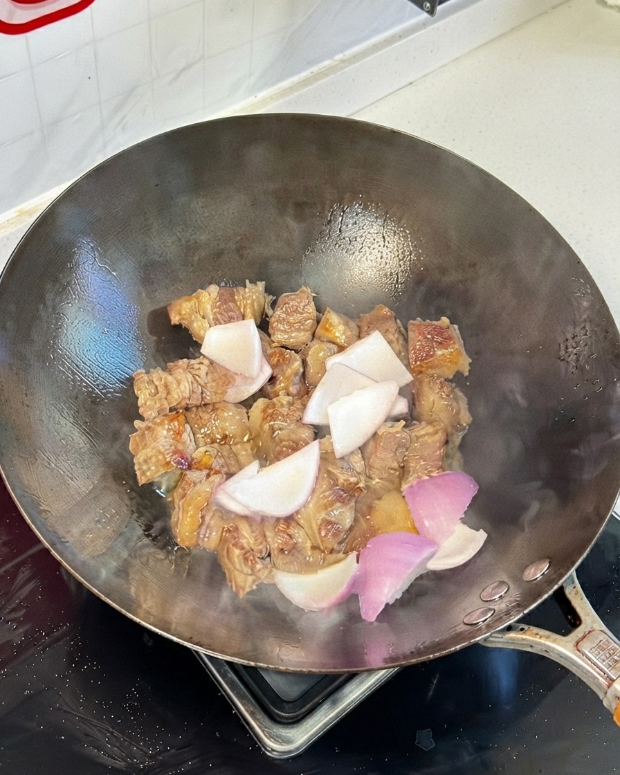 Angeröstete Rinderrippchen im Wok vermischt mit Zwiebelstücken und Sojasoßen.