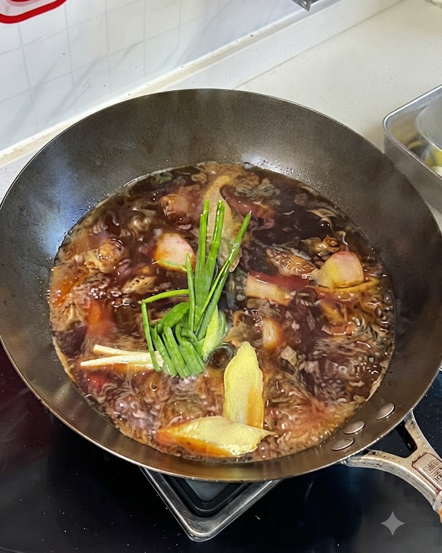Köchelnde Flüssigkeit in einem Wok mit Frühlingszwiebeln, Ingwer und Gewürzen auf dem Fleisch.