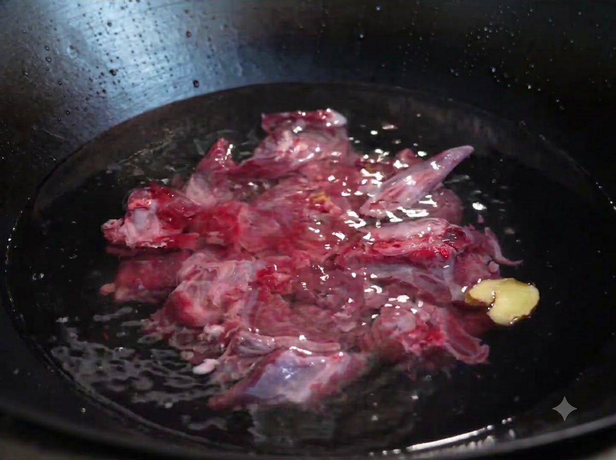 Rohe Rinderrippen, eingetaucht in kaltes Wasser in einem Wok, zusammen mit in Scheiben geschnittenem Ingwer und einer Frühlingszwiebel.