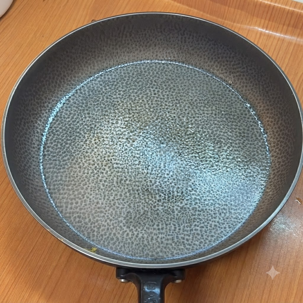 Eine leere, erhitzte Bratpfanne mit strukturierter Oberfläche auf einer Küchentheke.