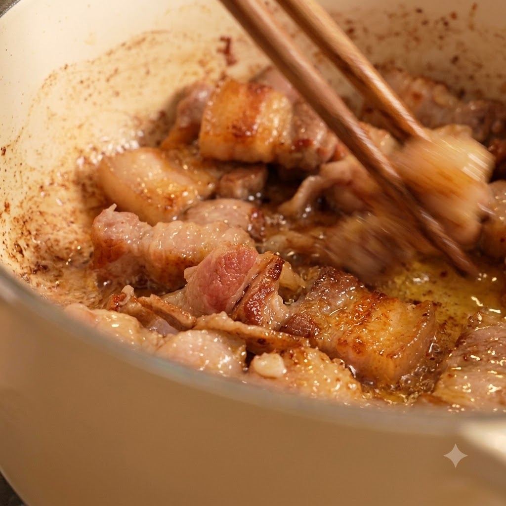 Essstäbchen rühren gebräunte Fleischstücke um, die in Öl in einem weißen Topf braten.