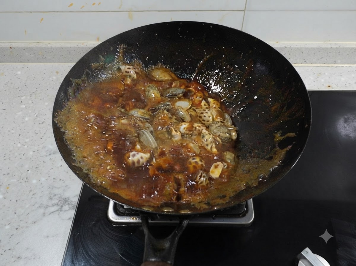 Meereschnecken und Baby-Oktopus köcheln in einer dunklen, stark blubbernden roten scharfen Brühe in einem schwarzen Wok.