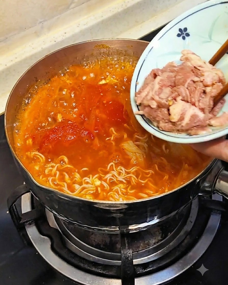 Stäbchen tauchen rohes, dünn geschnittenes Fleisch von einem kleinen Teller in die heiße Brühe.