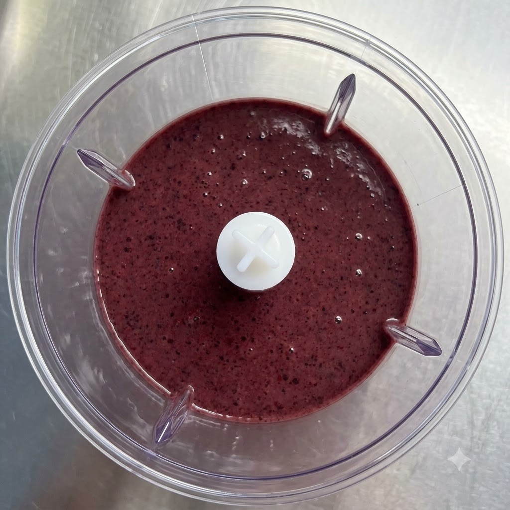 Ein klares Glas wird mit einem lila Smoothie gefüllt.