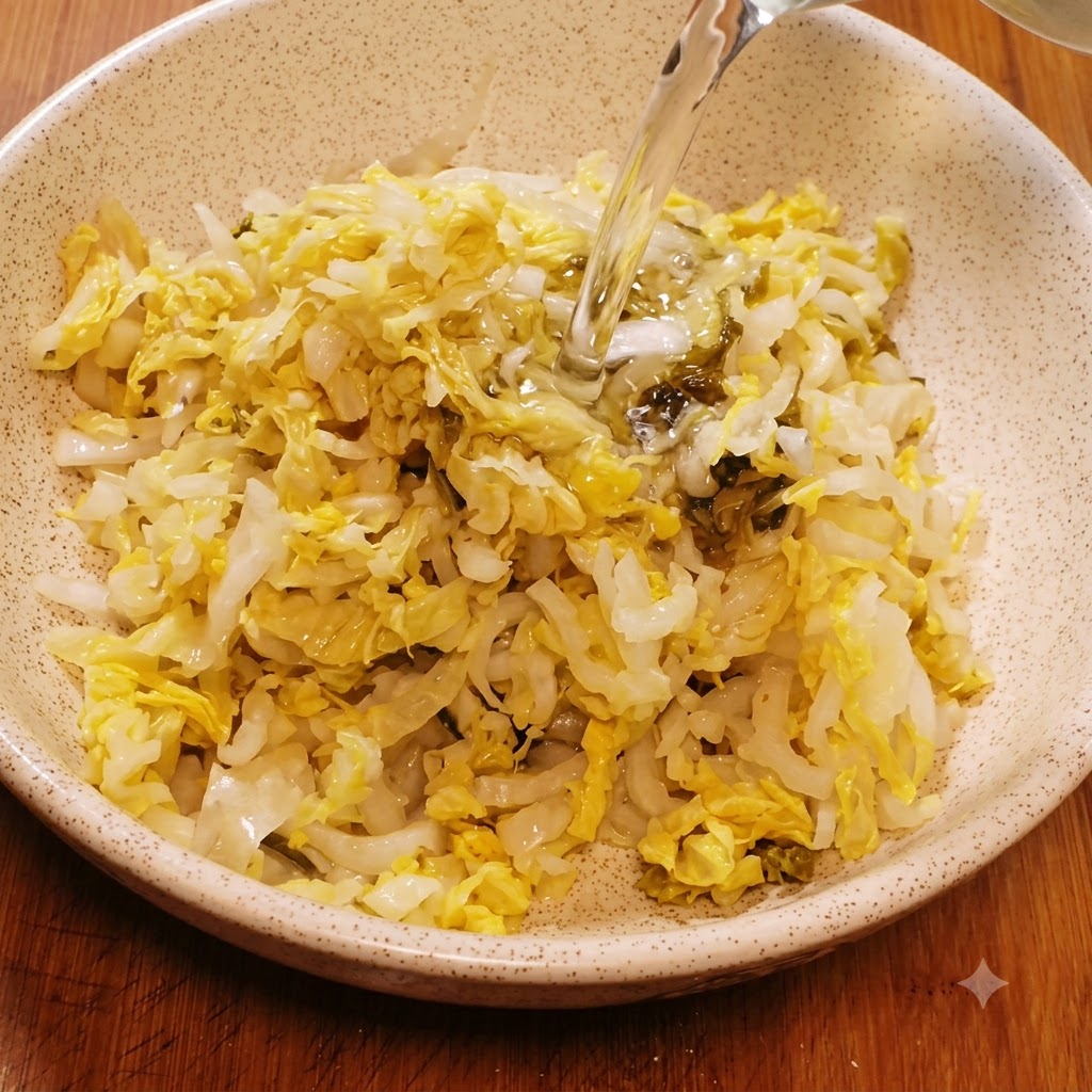 Wasser wird in eine Keramisschüssel mit zerkleinertem Sauerkraut zum Waschen gegossen.