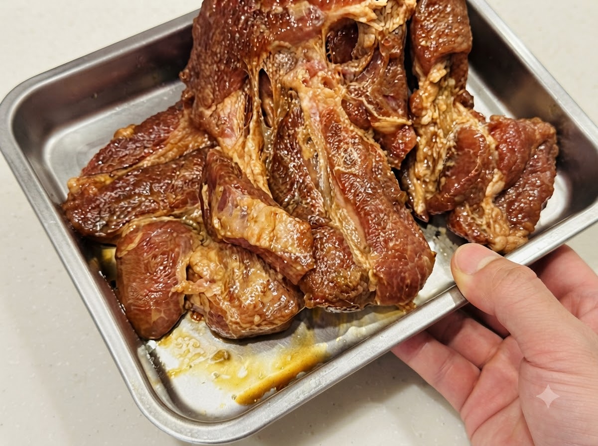 Schweinekoteletts flach in einer einzigen Schicht in einem mit Folie ausgelegten Backblech aus Metall ausgelegt.