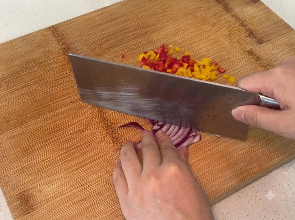Rote Zwiebel wird auf einem Holzschneidebrett in kleine Stücke gehackt.