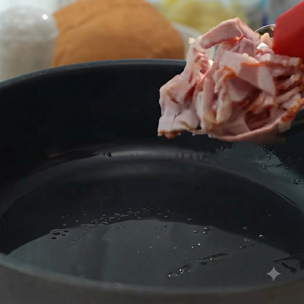 Speckstücke werden in eine Pfanne gegeben, um sie knusprig und braun zu braten.