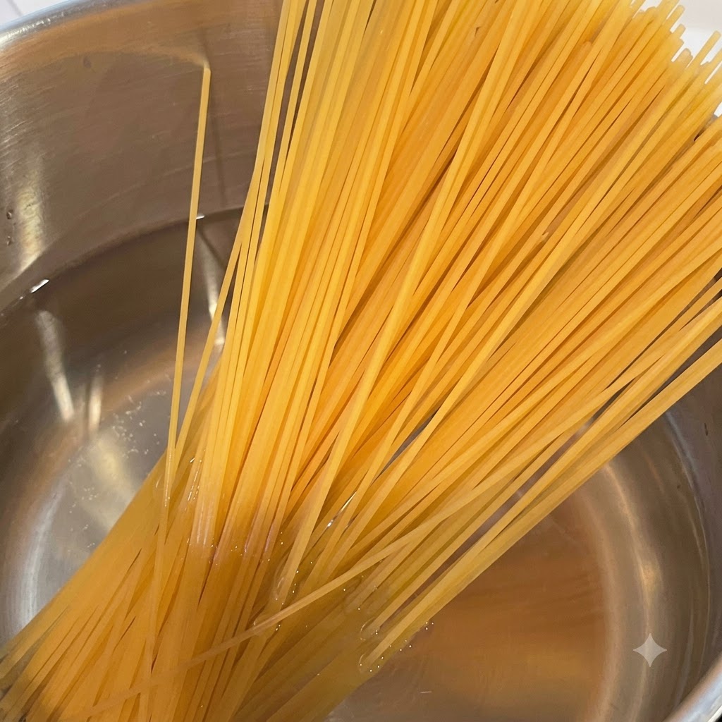 Ein Bündel trockene Spaghetti über einem Topf mit kochendem, dampfendem Wasser.
