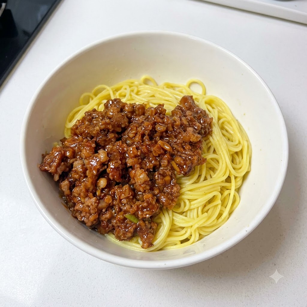 Eine Schüssel mit Nudeln und Hackfleischsoße, getoppt mit frisch gehackten Frühlingszwiebeln.