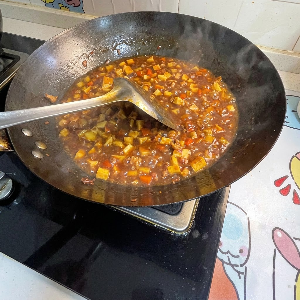 In Wasser gelöste Speisestärke wird in die blubbernde Sauce im Wok gerührt, um sie anzudicken.