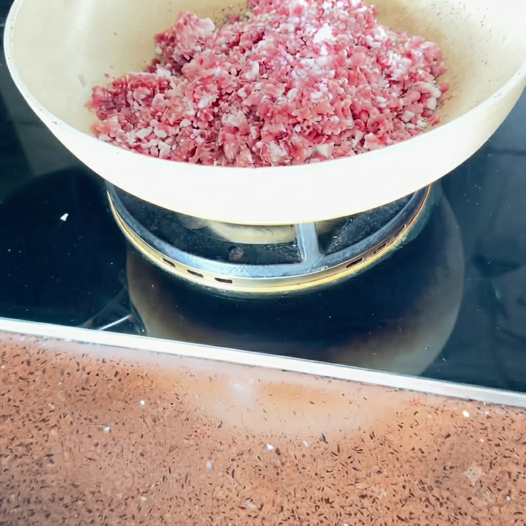 Schweinebauchwürfel werden in einer Pfanne bei mittlerer Hitze angebraten.