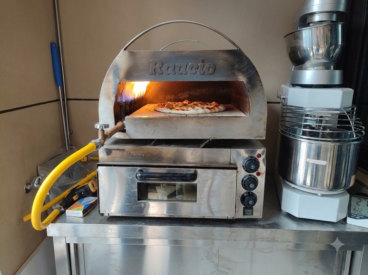 Eine rohe Pizza backt in einem Edelstahl-Pizzaofen mit einer hellen Flamme auf der Rückseite.