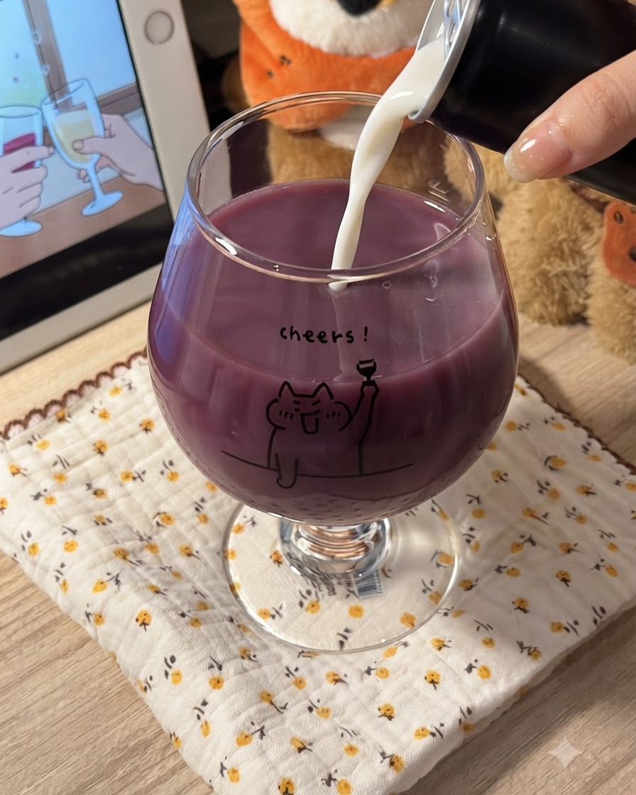 Weiße Milch wird in ein Glas mit violettem Traubensaft gegossen, wodurch eine cremige lila Mischung entsteht.