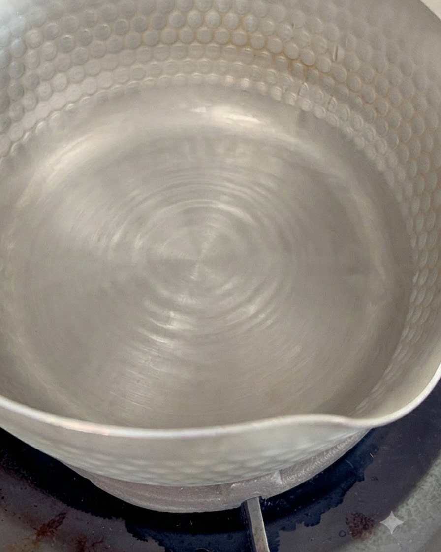Getrocknete Bonitoflocken kochen in einem kleinen Topf mit köchelndem Wasser, um eine aromatische Dashi-Brühe zu erzeugen.