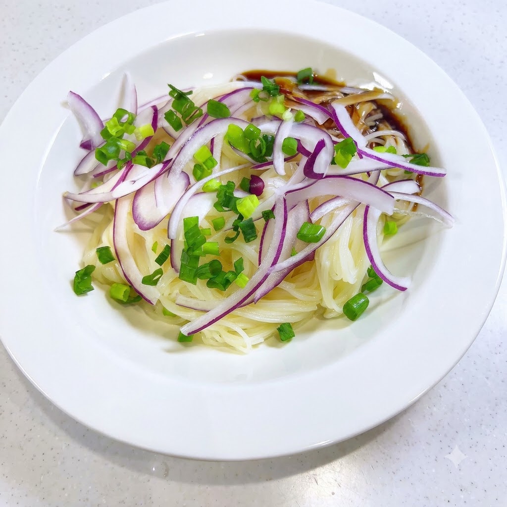 Dunkle, würzige Sauce wird an den Rand der Somen-Nudeln und Zwiebeln in einer weißen Schüssel gegossen.