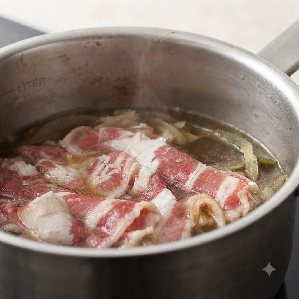 Gehackter Ingwer wird in einen Topf mit Rindfleisch und Zwiebeln in simmernder Brühe gegeben.