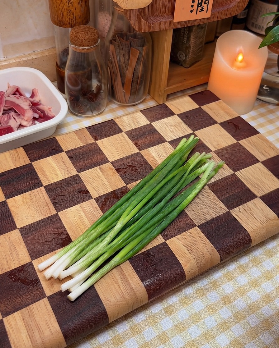 Frische Frühlingszwiebeln liegen bereit zum Hacken auf einem Holzbrett.
