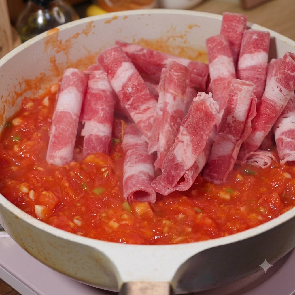 Geschnittenes Rindfleisch wird zu den Tomaten in die Pfanne gegeben.
