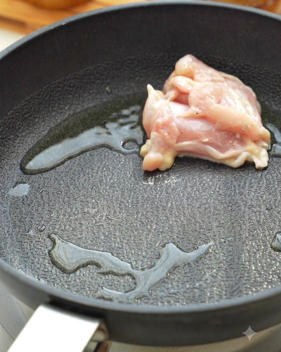 Rohe Hähnchenstücke braten in einer heißen Pfanne mit Öl.