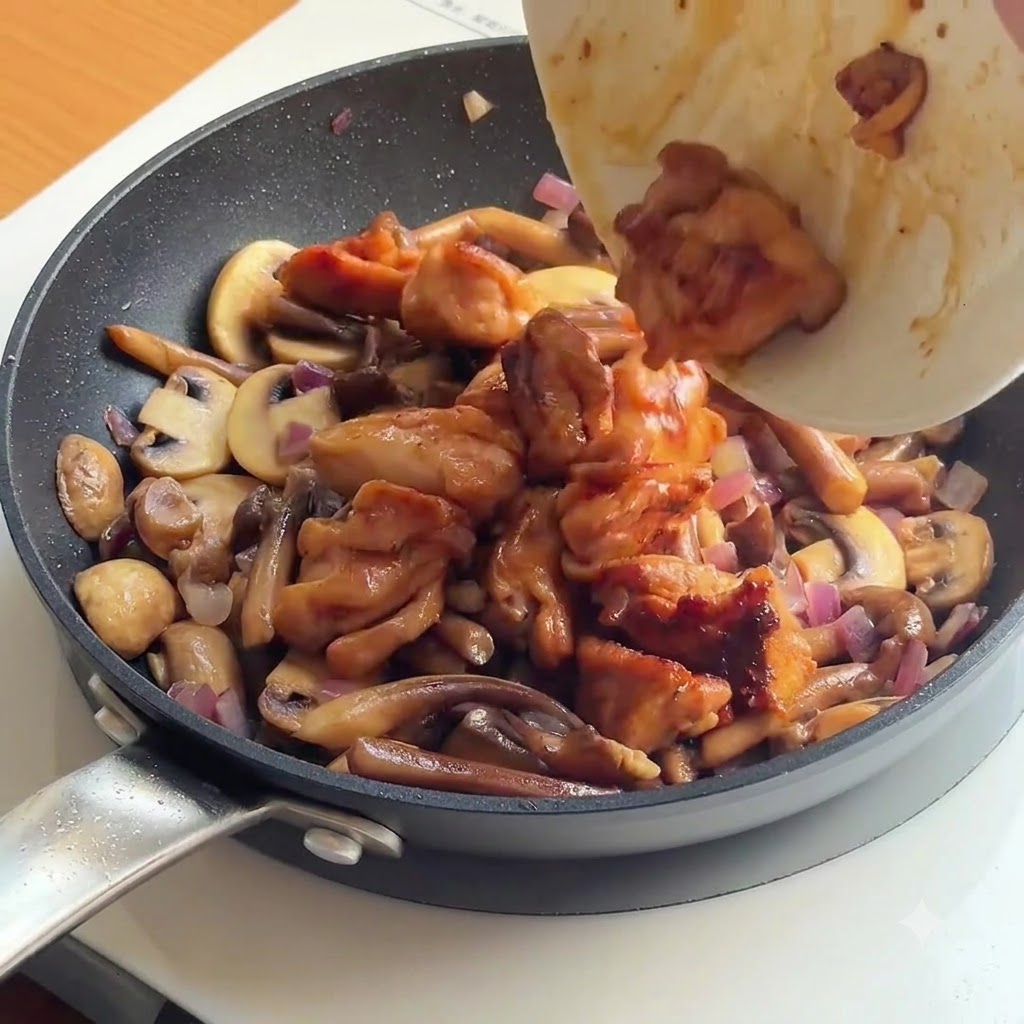 Gekochtes Hähnchen und weißer Reis werden in eine Pfanne mit sautierten Pilzen und Zwiebeln gegeben.
