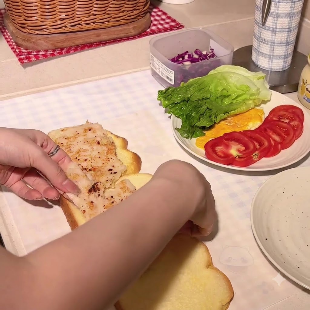 Honig-Senf wird auf eine Kürbisbrotscheibe mit einem Hähnchenschnitzel gedrückt.