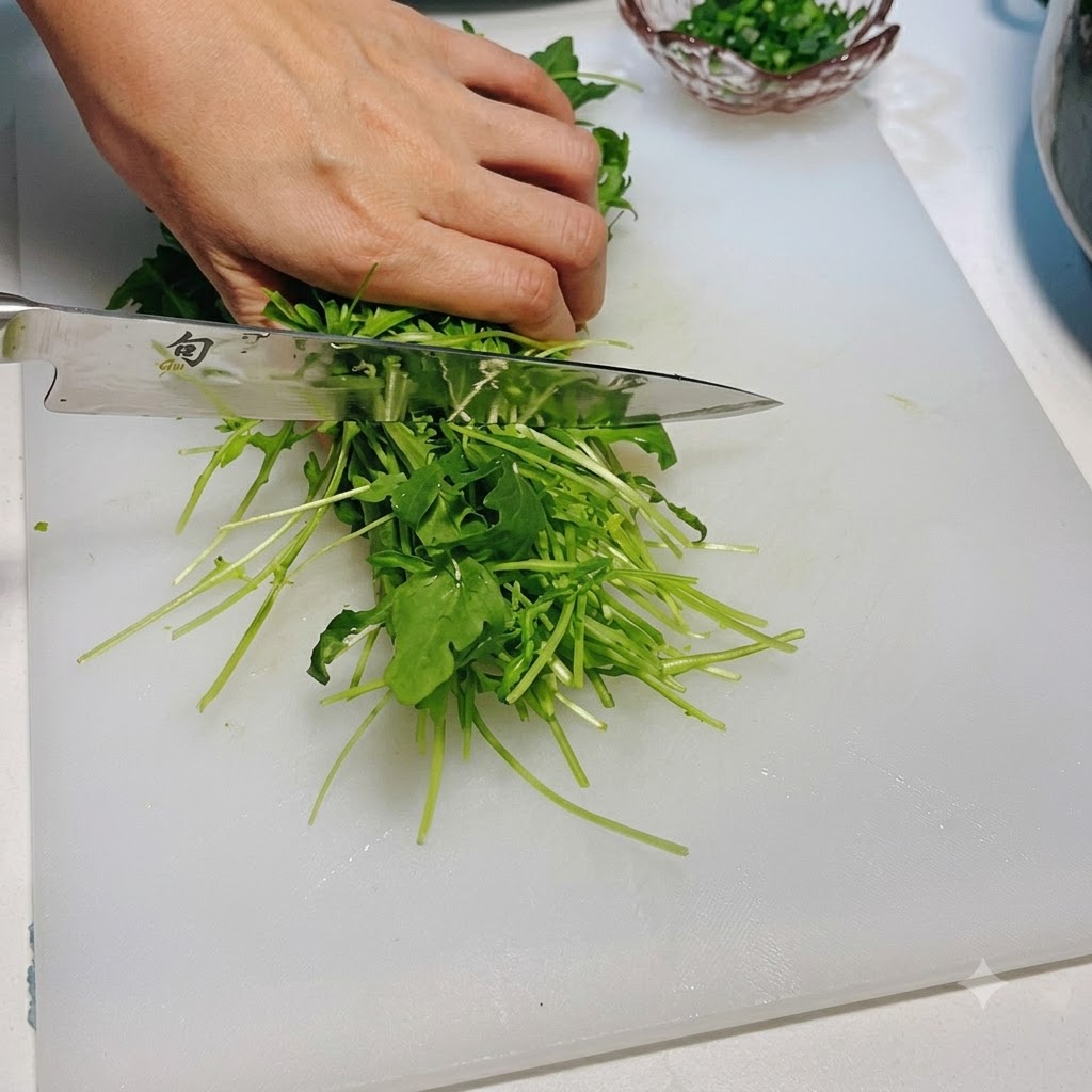 Frischer grüner Rucola wird mit einem Messer auf einem weißen Schneidebrett geschnitten.
