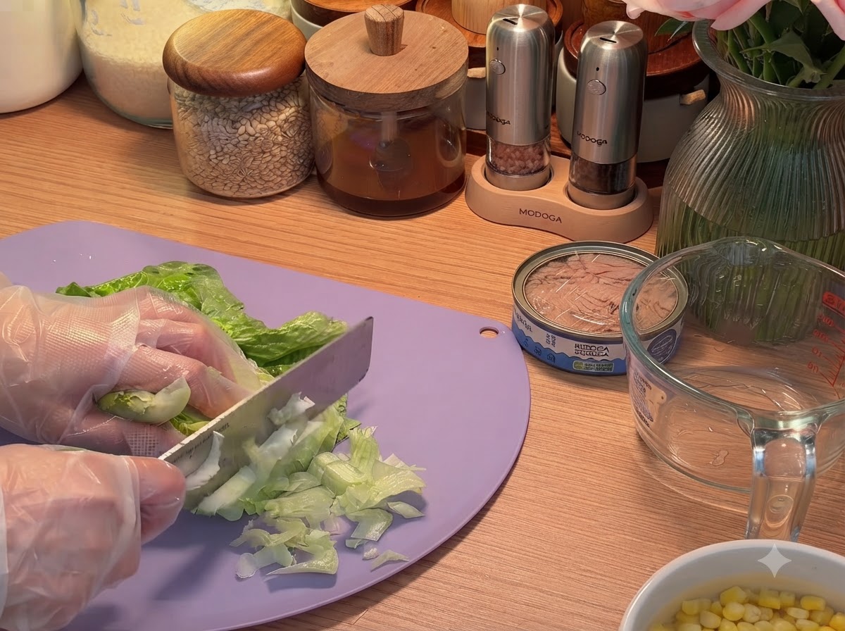 Frische Salatblätter werden auf einem Schneidebrett in feine Streifen geschnitten.