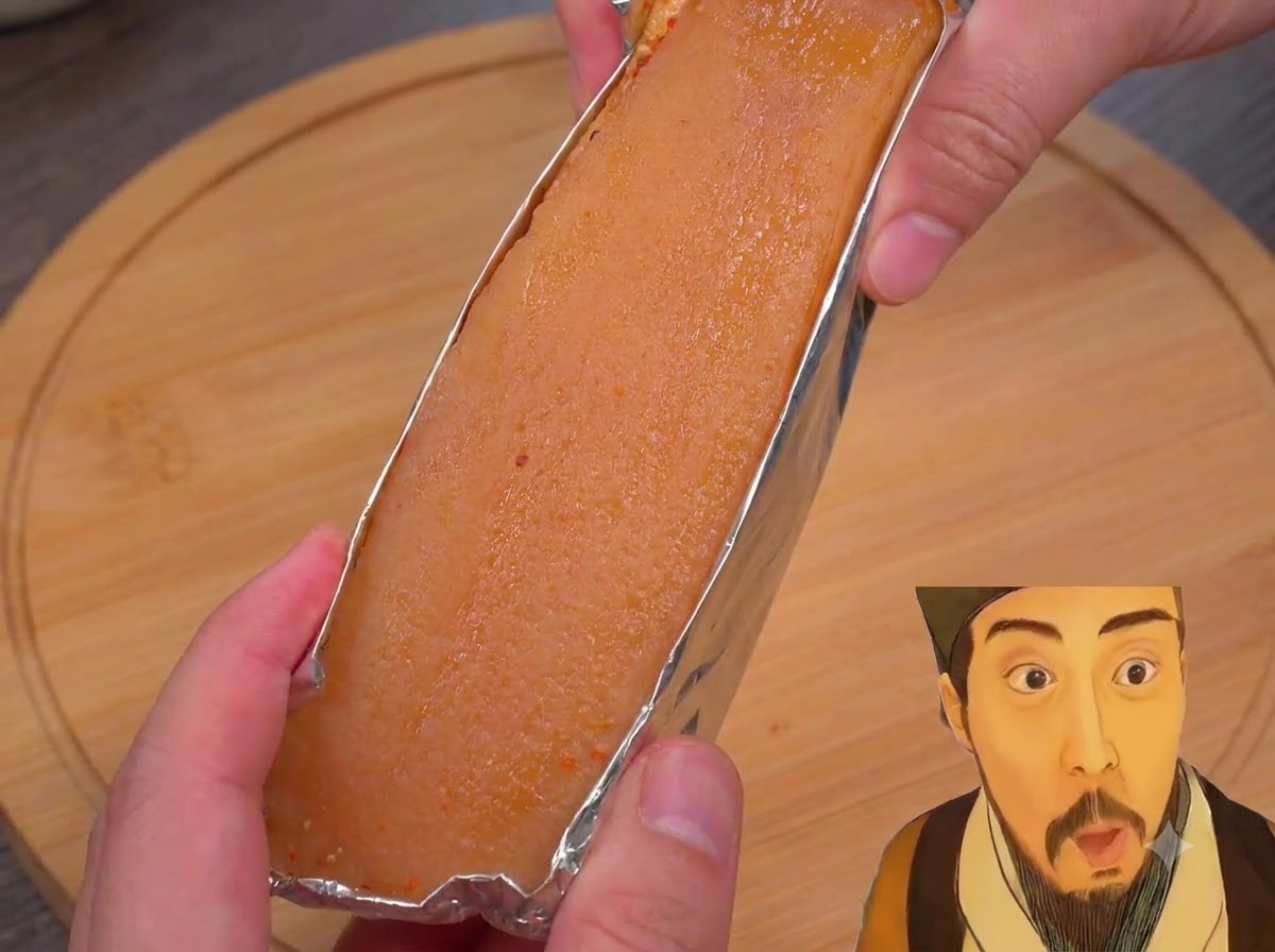 Eine Nahaufnahme von in Folie gewickelten Schweinebauchstreifen, die mit weißem Essig bestrichen werden.