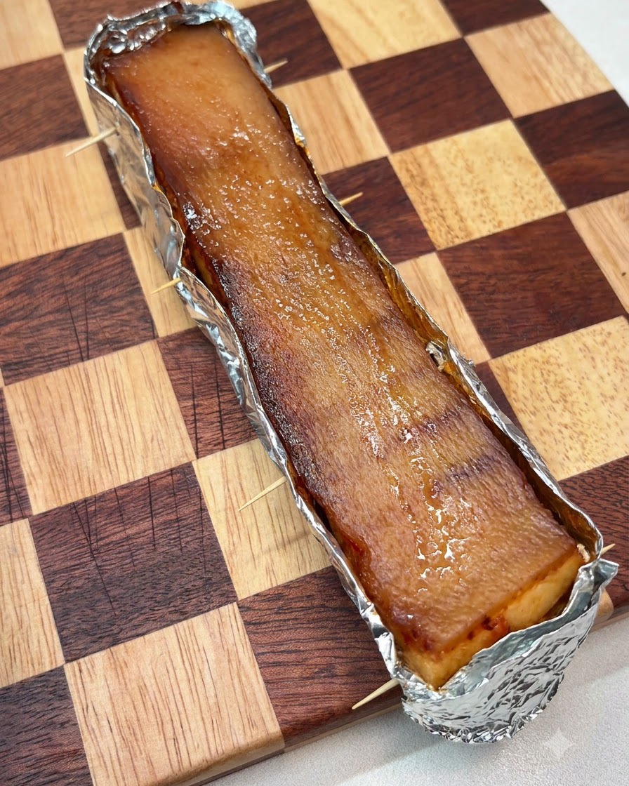 Eine dicke Schicht groben Salzes ist gleichmäßig auf der oberen Oberfläche der in Alufolie gewickelten Schweinehaut verteilt.