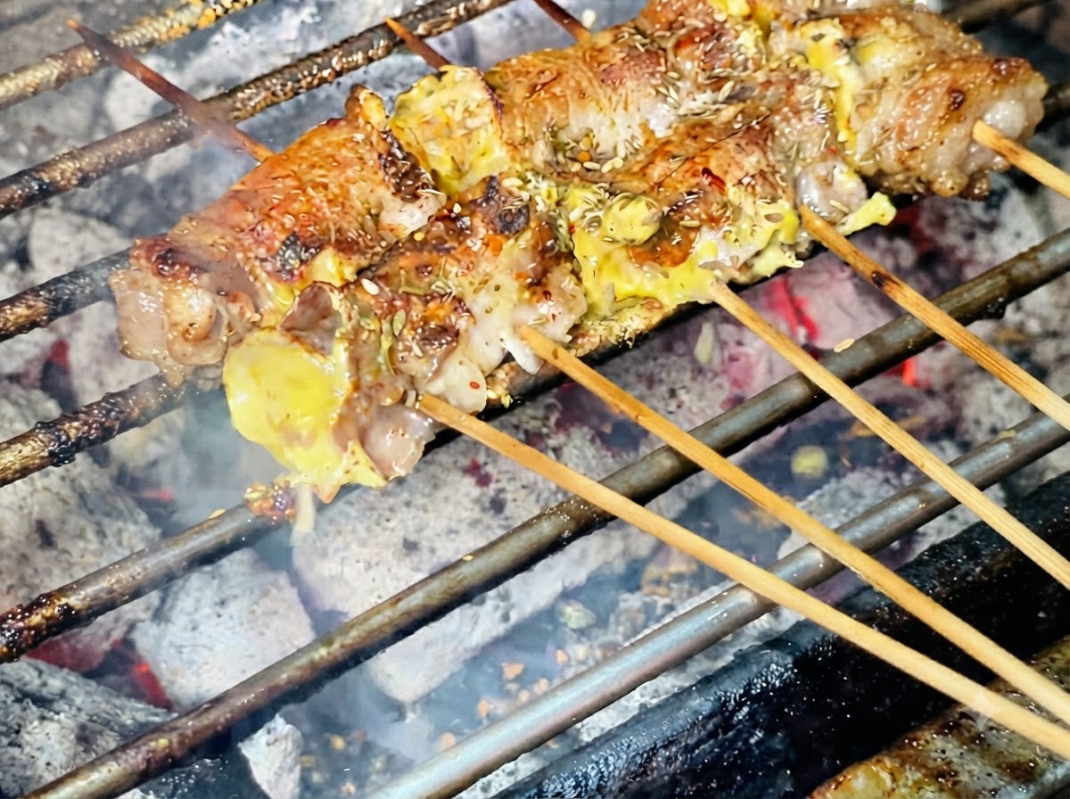 Sesamsamen werden oben auf die gegrillten Fleischrollen gestreut.