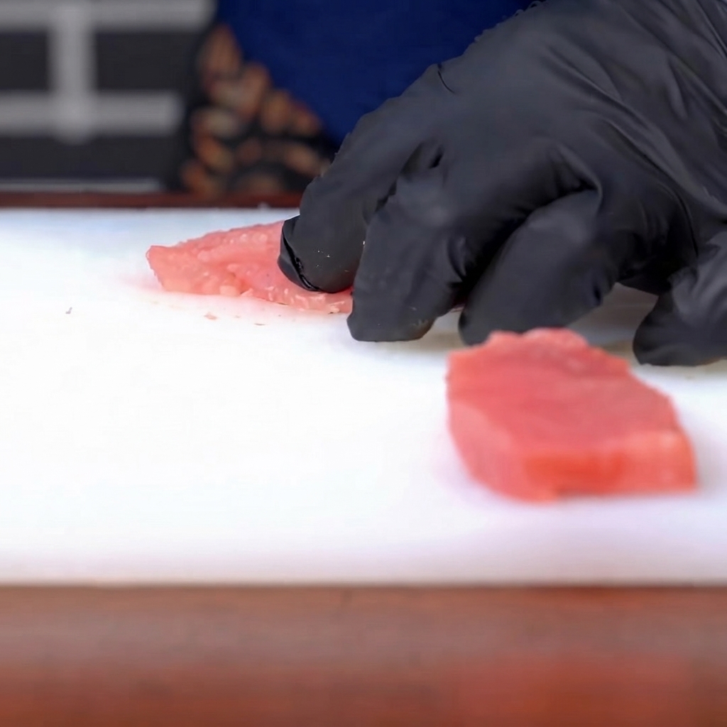 Salz und Pfeffer werden auf ein gewürztes rohes Schweineschnitzel gestreut.